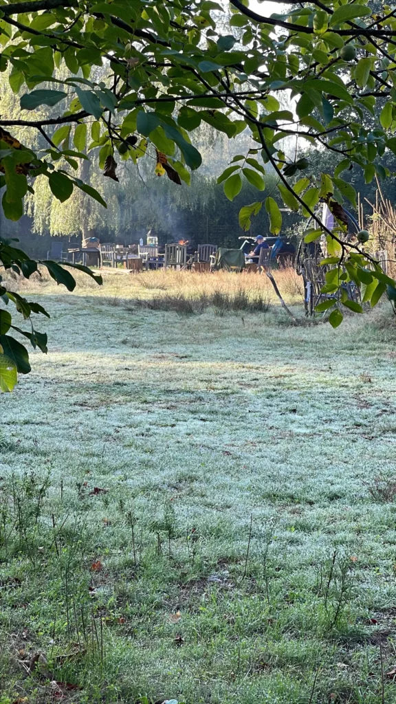 Persoon alleen bij de kampvuurplek op het open veld